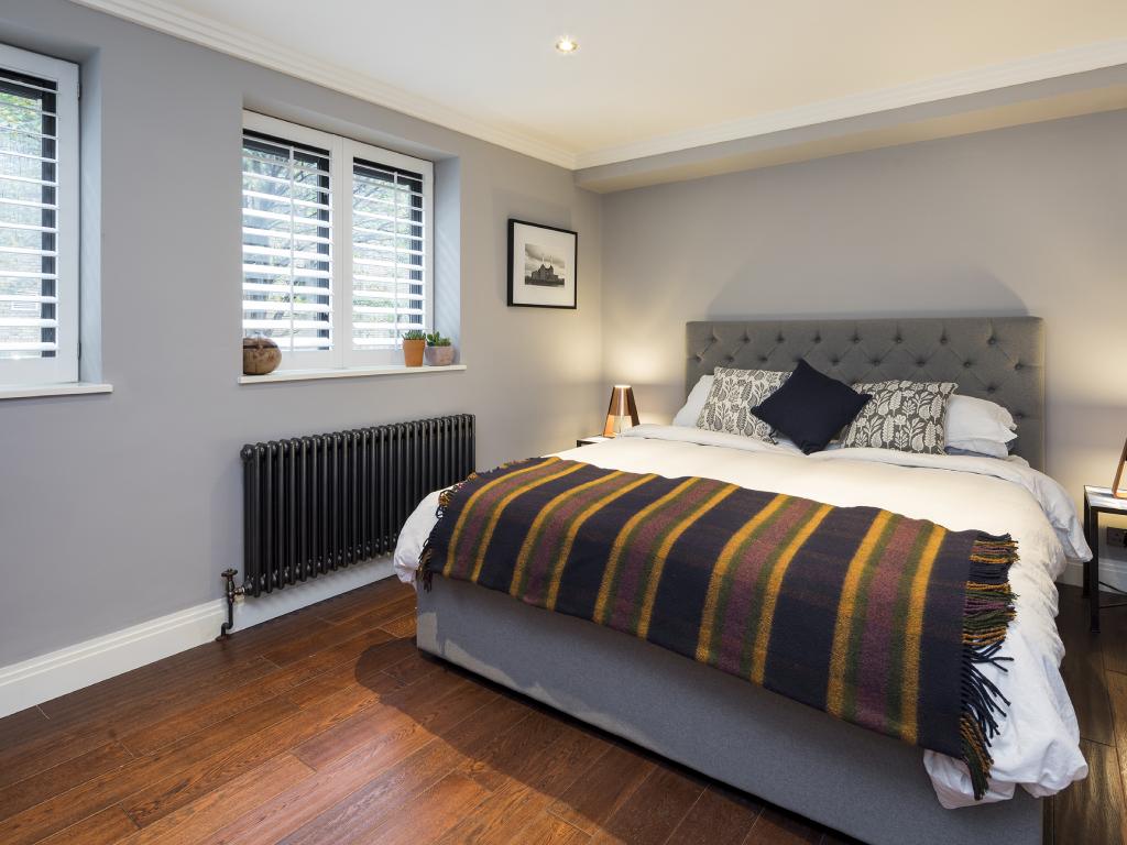 Bedroom with white plantation shutters covering the windows.