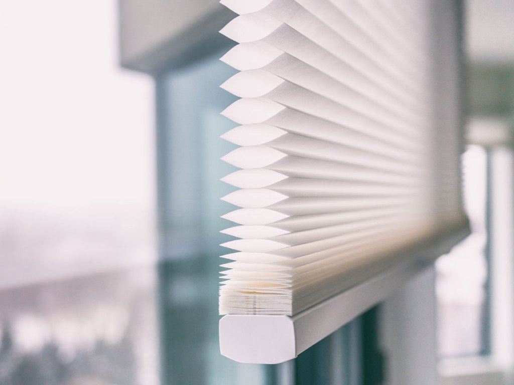 Close-up view of white cellular shades with their distinct honeycomb structure.