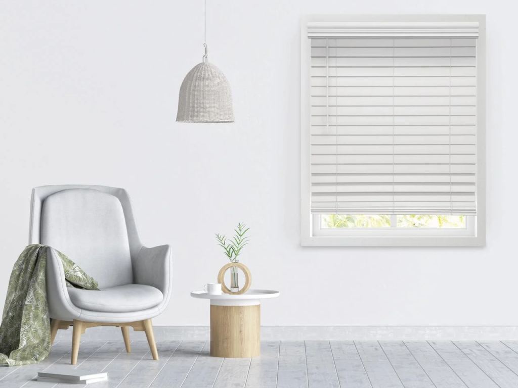 Minimalist living room with white faux wood blinds covering the window.