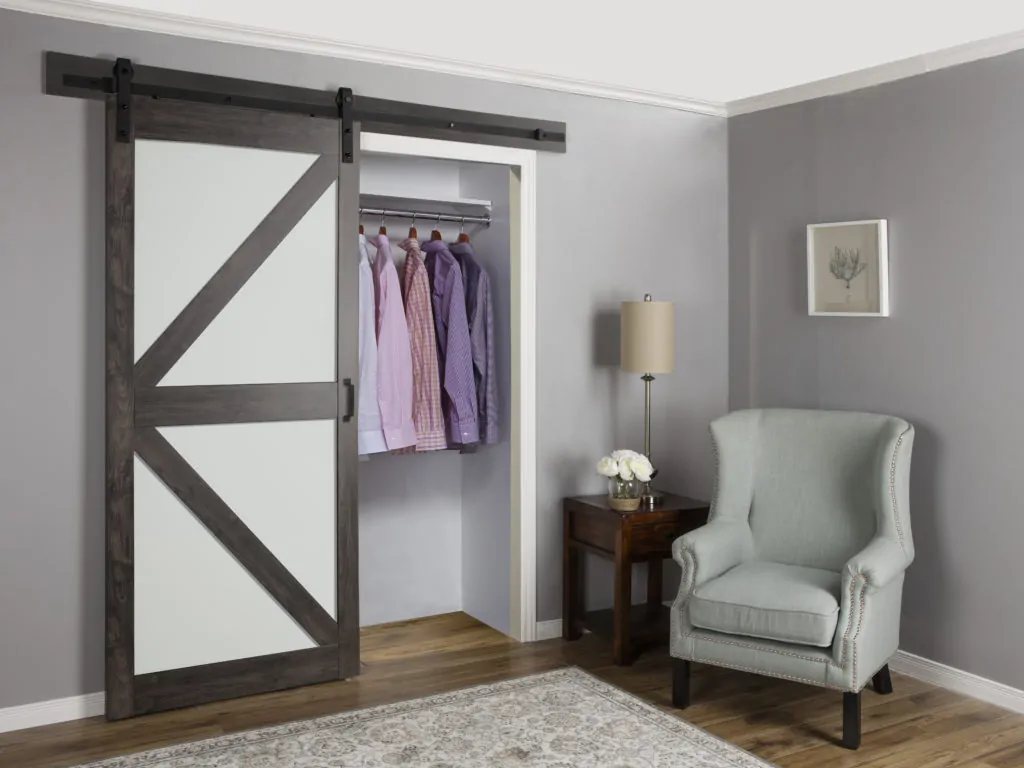 Modern bedroom with a white and gray sliding barn door covering a closet.