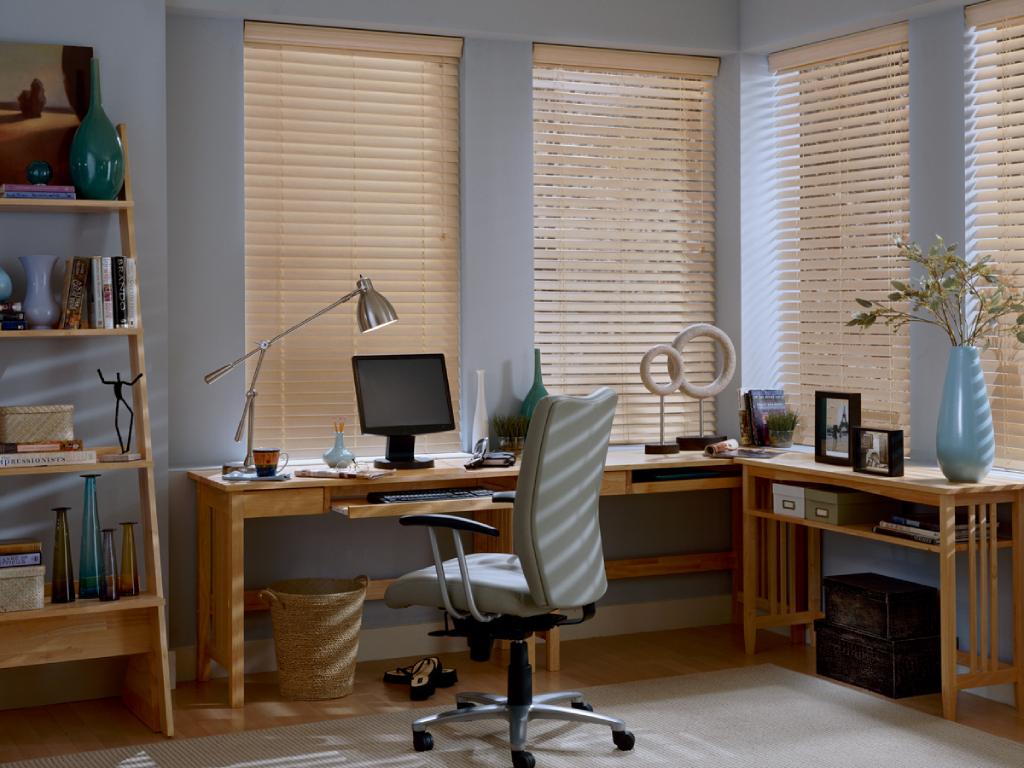 Home office with wood blinds covering the windows.