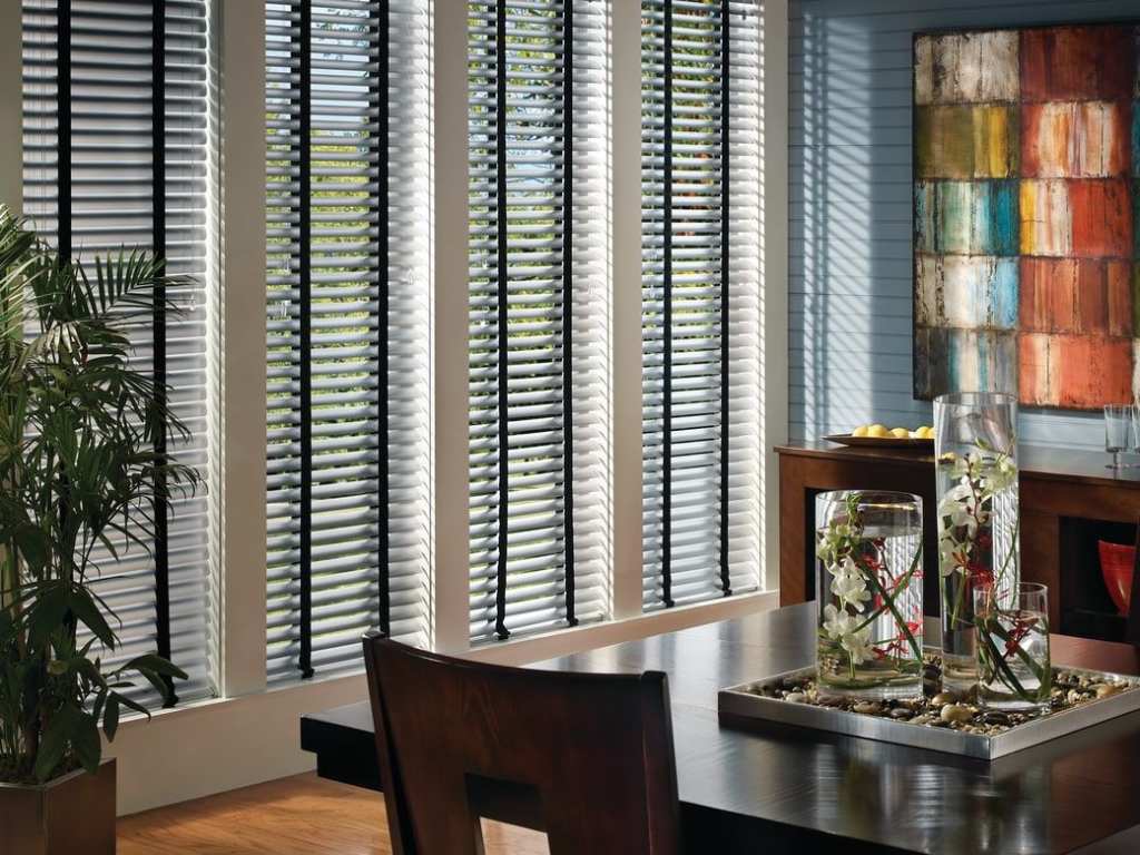 Modern dining room with vertical blinds on large windows.