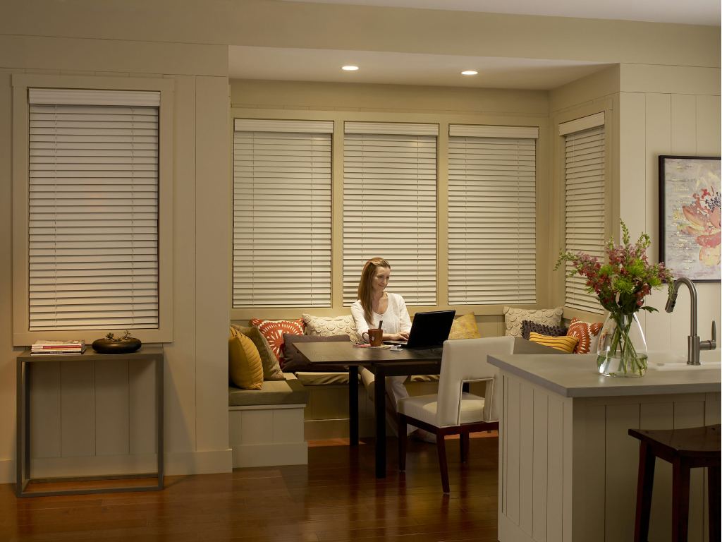 Cozy kitchen with wood blinds covering the windows.