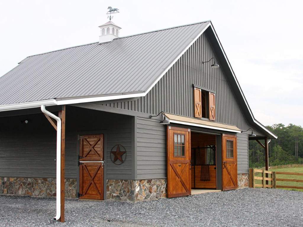 Gray barn with wooden Dutch doors and a metal roof.