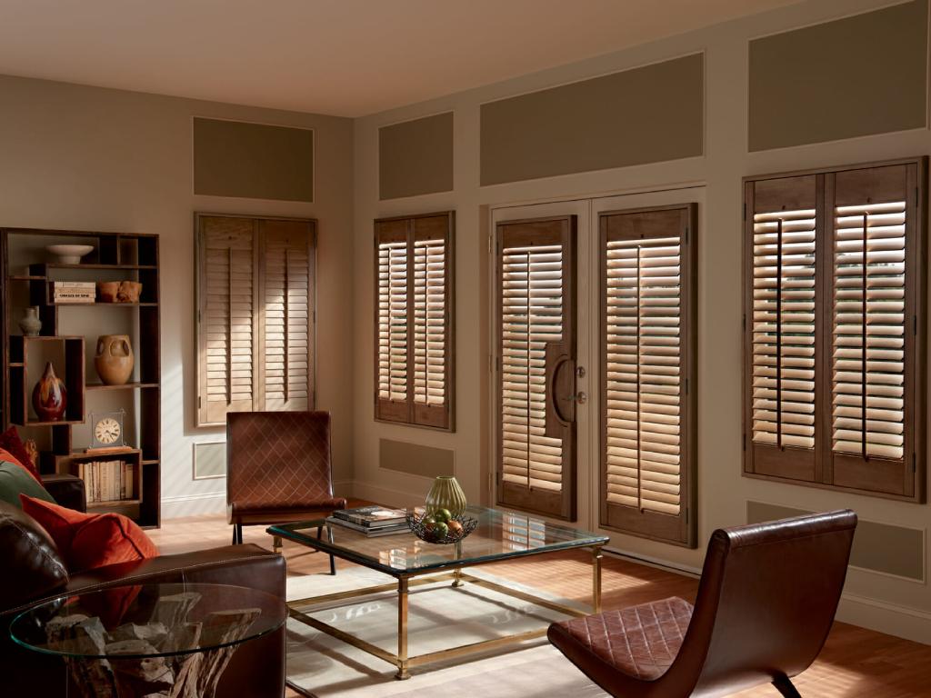 Living room with wood plantation shutters covering the windows and French doors.