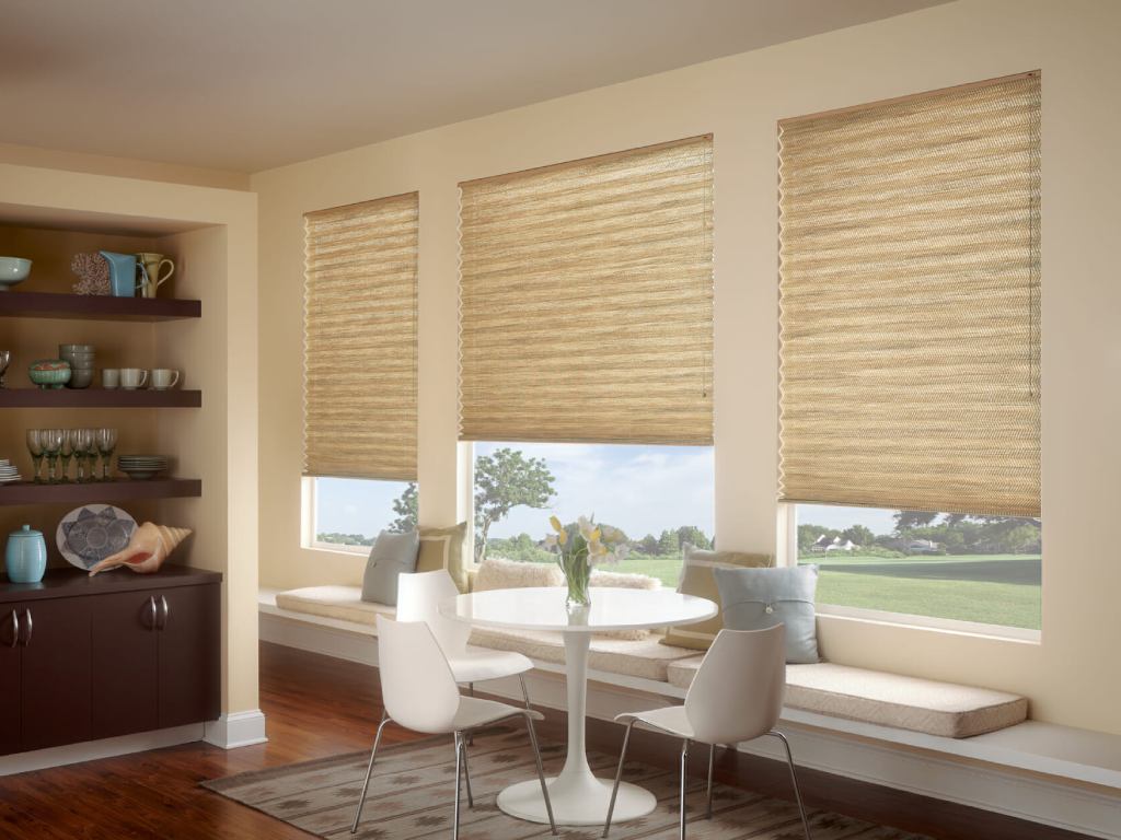 Sunlit dining area with cellular shades covering the windows, creating a warm and inviting ambiance.