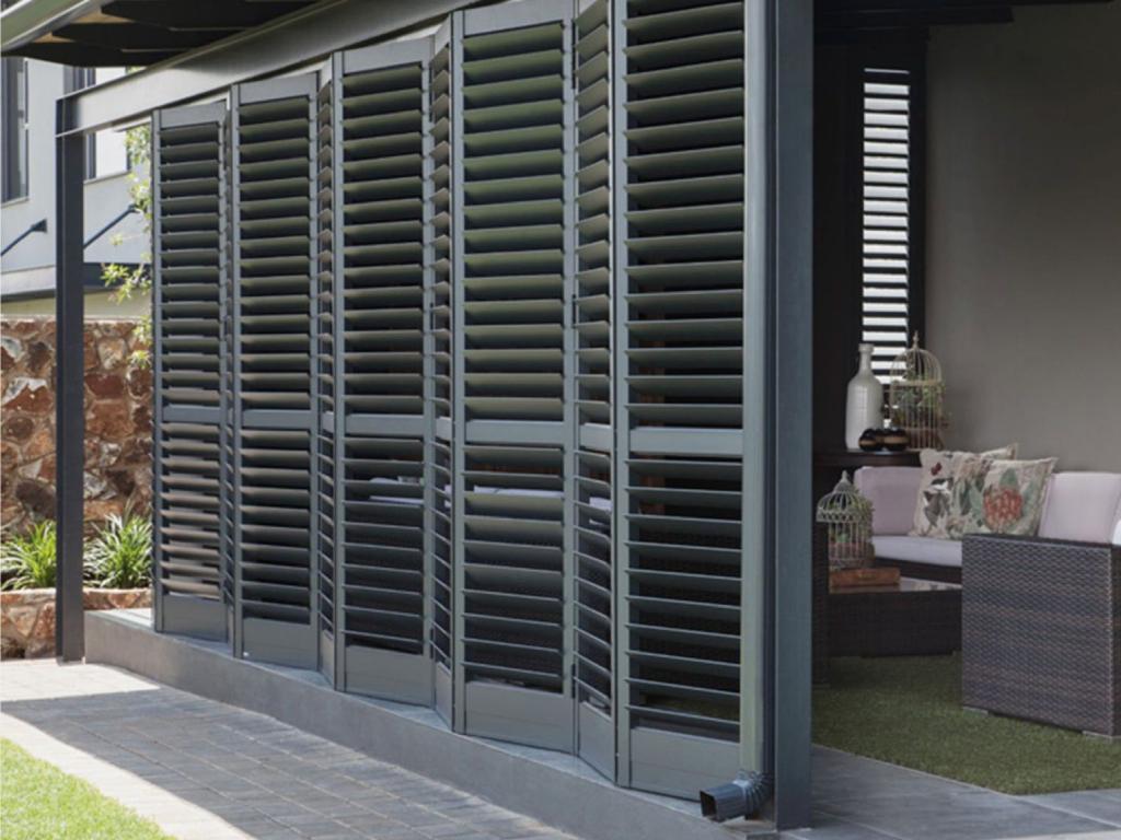 Patio doors covered with gray bypass plantation shutters.