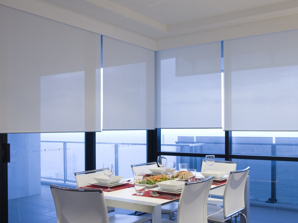 Dining room with modern solar shades filtering bright sunlight.