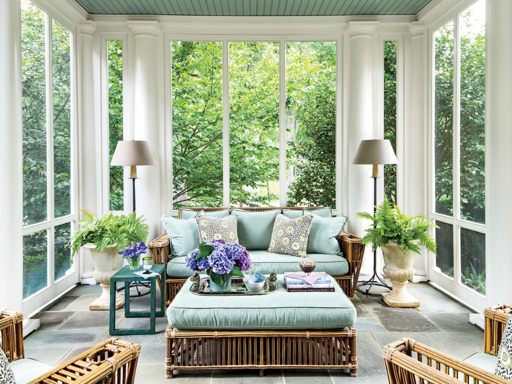 Sunroom with white plantation shutters on the windows.