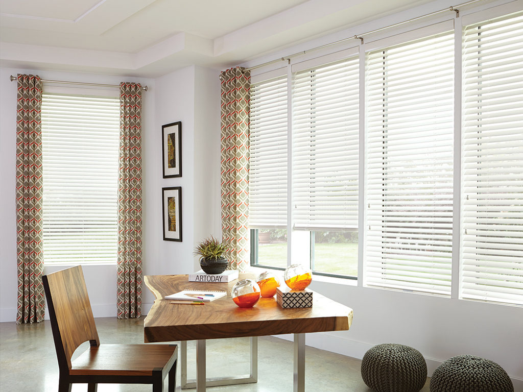 Bright dining area with natural light streaming through wood blinds.