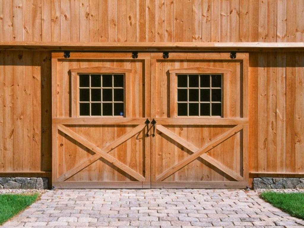 Rustic sliding barn door with glass panes and black hardware.