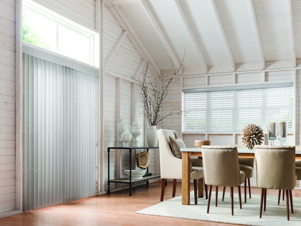 Bright dining room with vertical blinds and horizontal blinds on different windows.