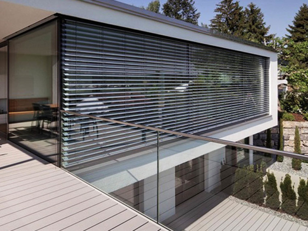 Modern building with exterior Venetian blinds covering the windows.