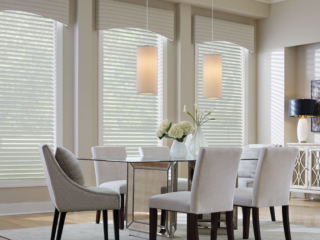 Dining room with elegant Roman shades covering the windows.