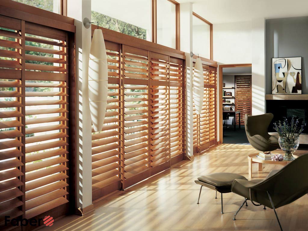 Sun-drenched living room with wood plantation shutters covering large windows.