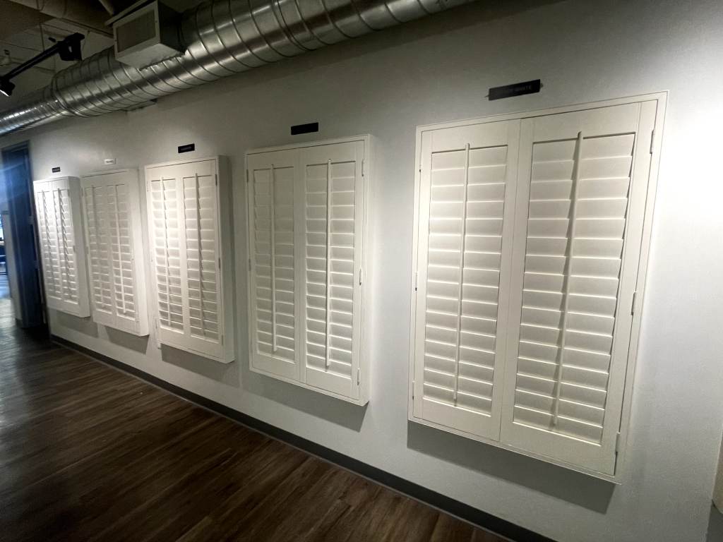 Bright living room with white plantation shutters covering the windows.